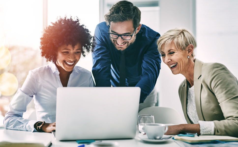A group of marketers laughing and viewing untapped market opportunities on a laptop provided by ERS's streaming measurement solution.