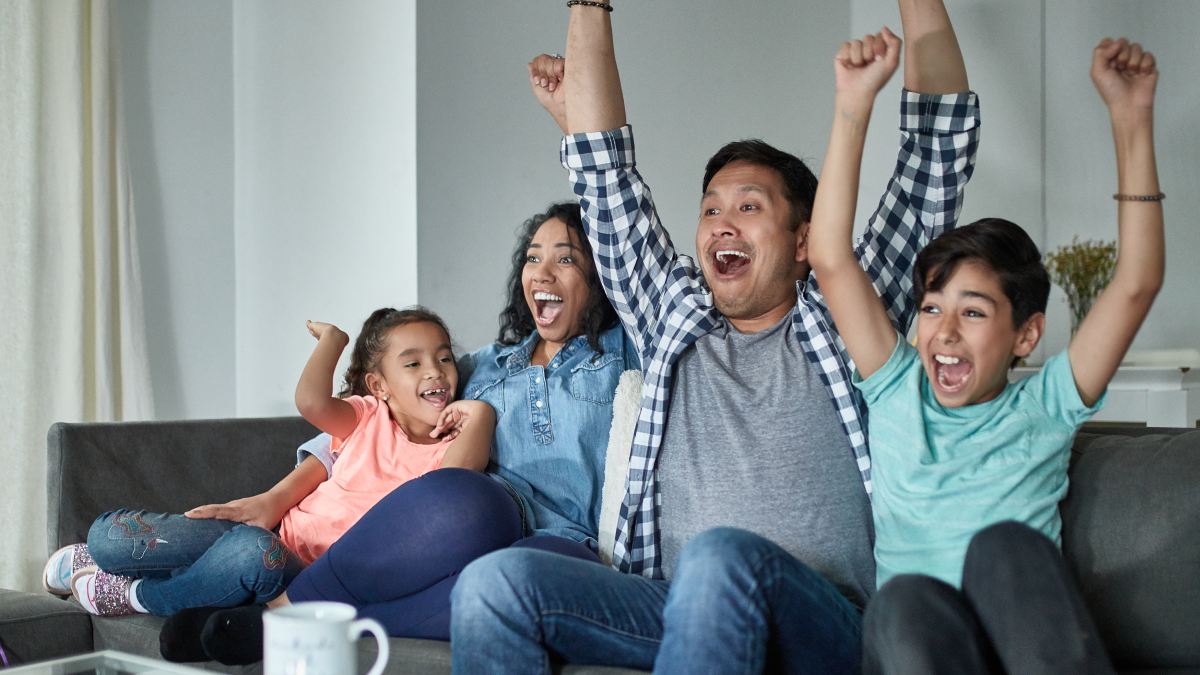 A family cheering and enjoying their TV show whose data will be collected via ERS's linear tv measurement.