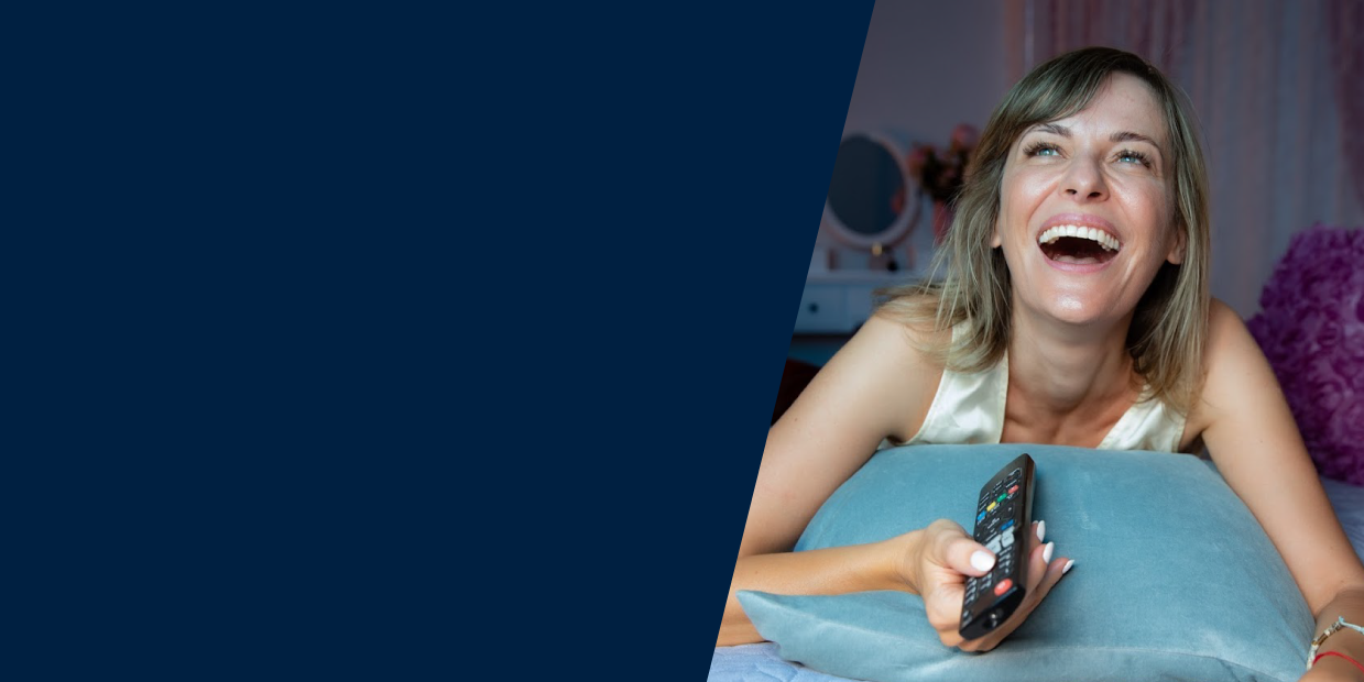 Woman laughing and watching TV internationally whose data will be collected via ERS's linear tv measurement.